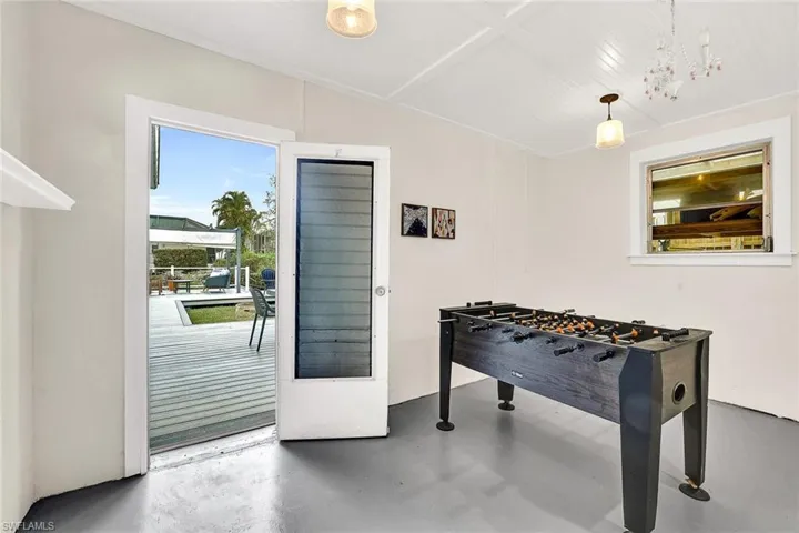 Garage space has been transformed into a gaming area with access to the backyard.