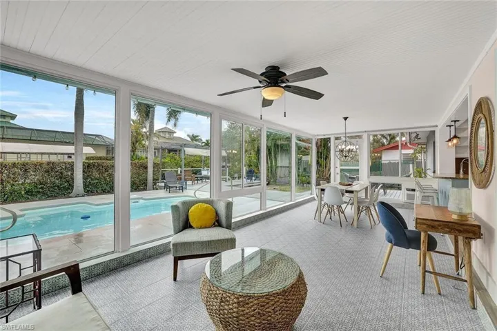 Florida room is the perfect spot for morning coffee.  Notice the floor to ceiling windows!