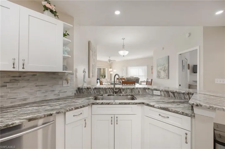 Kitchen with open shelves, white cabinetry, dishwasher, pendant lighting, and open floor plan