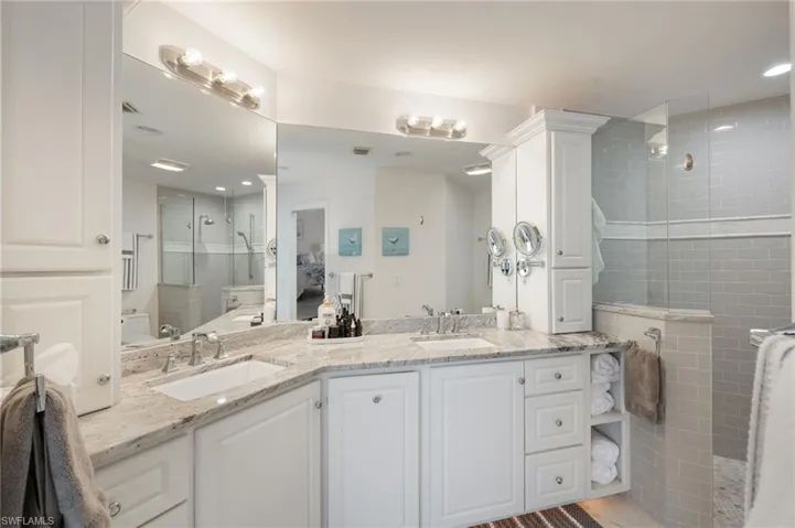 Full bath featuring double vanity, walk in shower, and recessed lighting