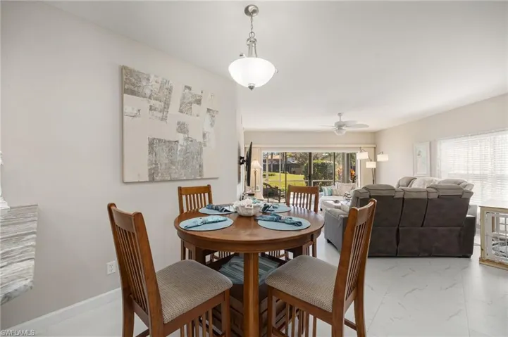 Dining room with marble look tiles and a ceiling fan