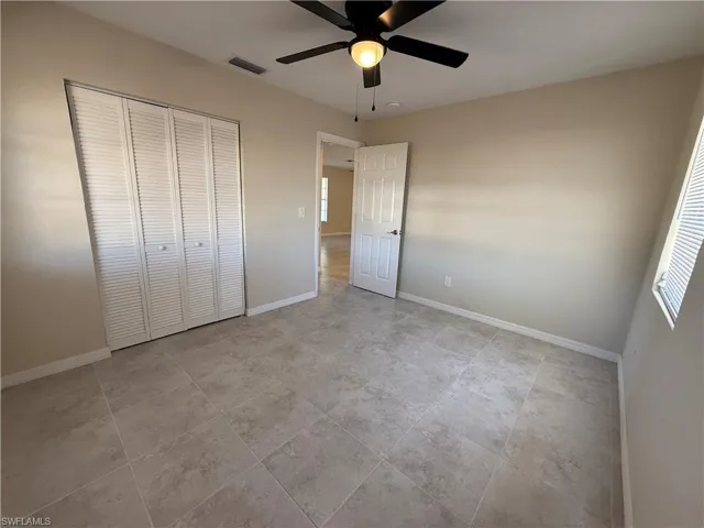 Unfurnished bedroom with a ceiling fan and a closet