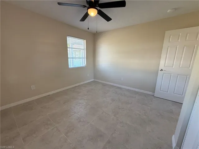 Spare room with baseboards and a ceiling fan