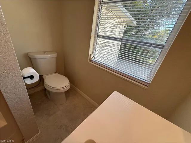 Bathroom featuring tile patterned flooring and a textured wall