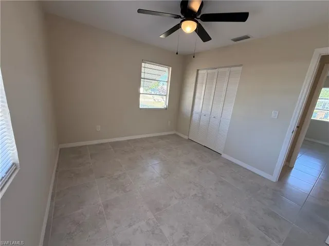 Unfurnished bedroom featuring ceiling fan, a closet, and light tile patterned flooring