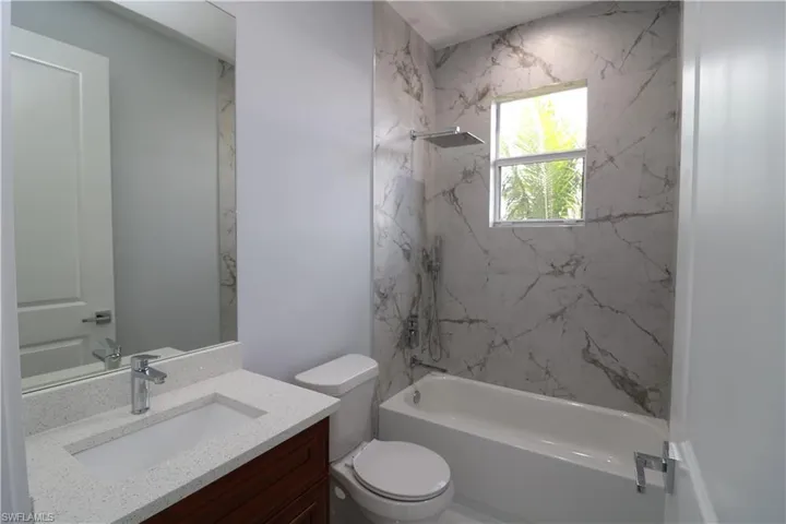 Full bathroom featuring vanity, toilet, and tiled shower / bath