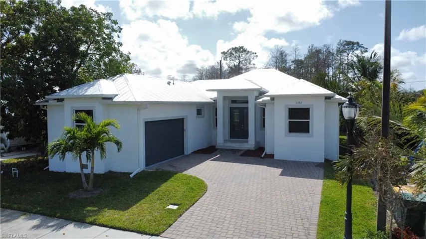 View of front facade featuring a garage and a front lawn