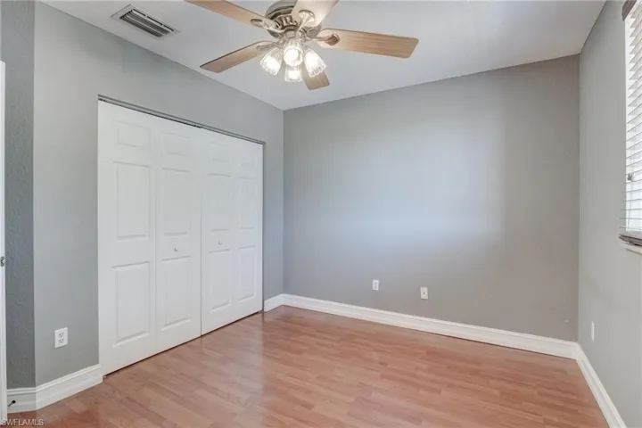 Bedroom featuring light hardwood / wood-style floors, ceiling fan, and a closet