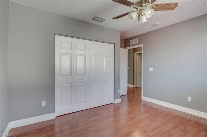 Bedroom with ceiling fan, light hardwood / wood-style floors, and a closet