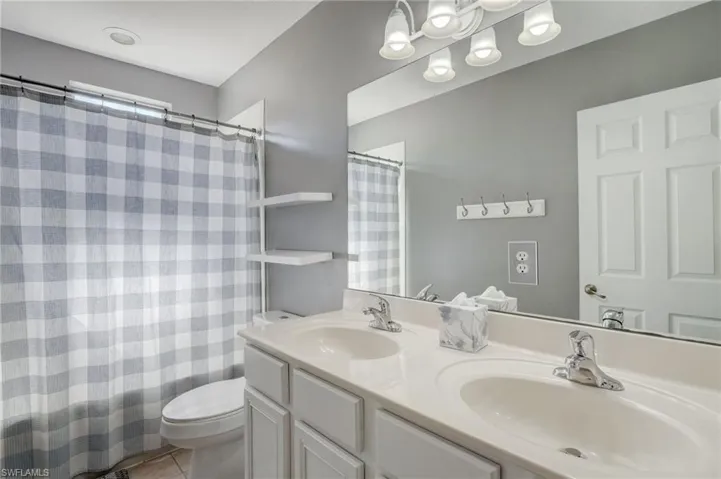 Bathroom with vanity, toilet, and tile patterned flooring