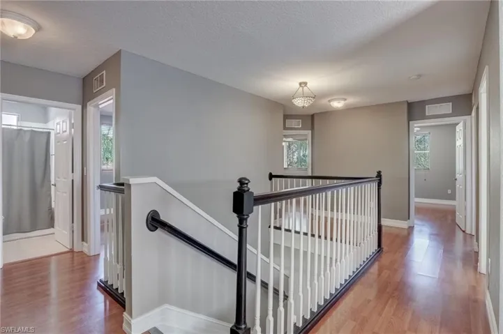 Stairs with hardwood / wood-style flooring and a healthy amount of sunlight