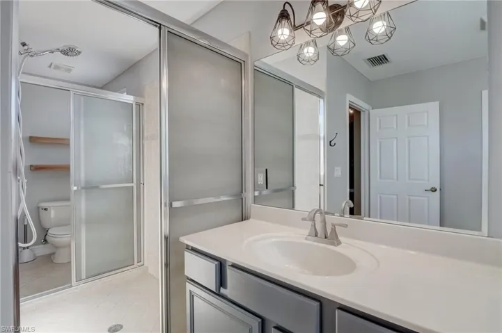 Master bathroom featuring vanity, tile patterned flooring, toilet, and walk in shower