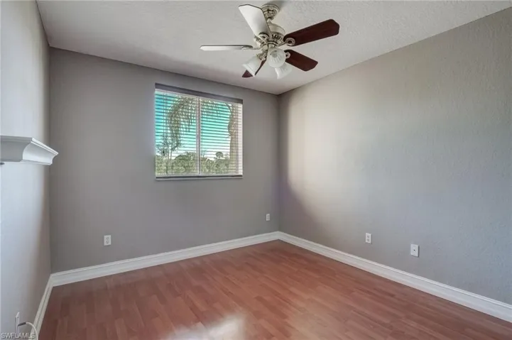 Bedroom featuring ceiling fan, hardwood / wood-style floors, and a textured ceiling