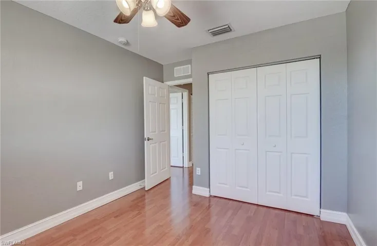 Bedroom featuring light hardwood / wood-style flooring, ceiling fan, and a closet