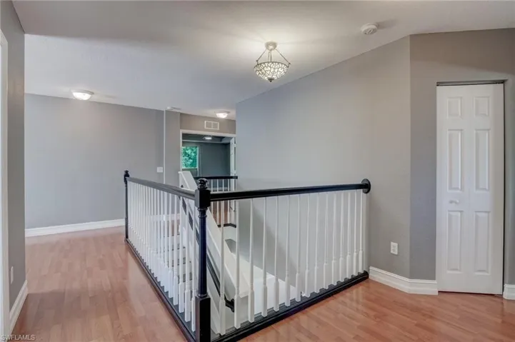 Corridor with hardwood / wood-style flooring