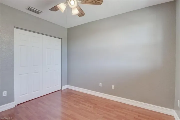 Bedroom featuring ceiling fan, a closet, and light hardwood / wood-style flooring