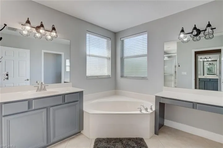Master bathroom featuring tile patterned flooring, vanity, and shower with separate bathtub