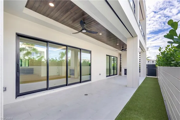 Covered Outdoor Lanai with gas fireplace and turf backyard area. Private gate to the pool!