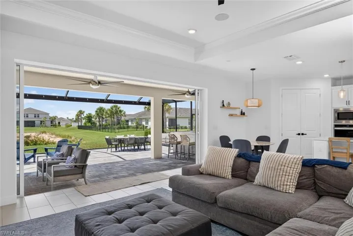 The spacious living space features dramatic pocket sliders that blur the lines between indoors and out, filling the home with natural light and showcasing the inviting outdoor living space
