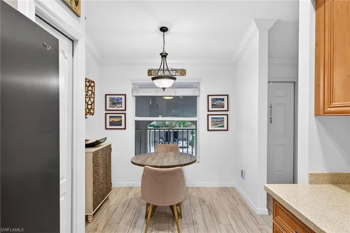 Dining room with crown molding and light wood-style flooring