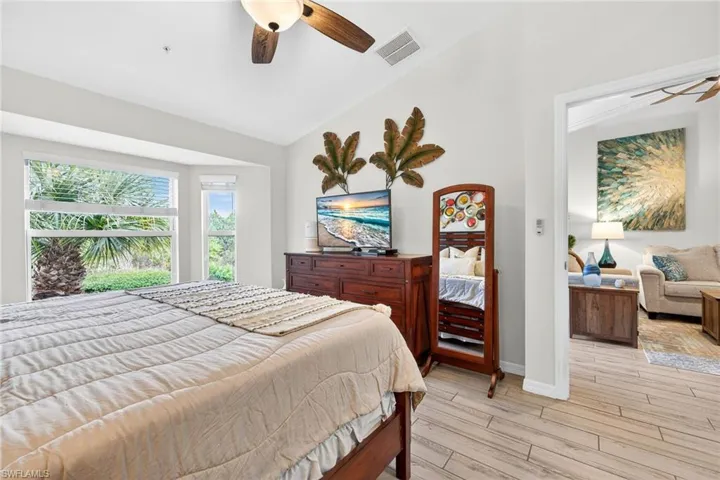 Bedroom featuring lofted ceiling, light wood finished floors, and ceiling fan