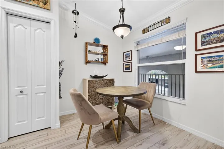 Dining space featuring ornamental molding and light wood-style flooring