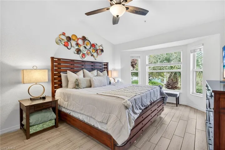 Bedroom with wood finish floors, ceiling fan, and vaulted ceiling