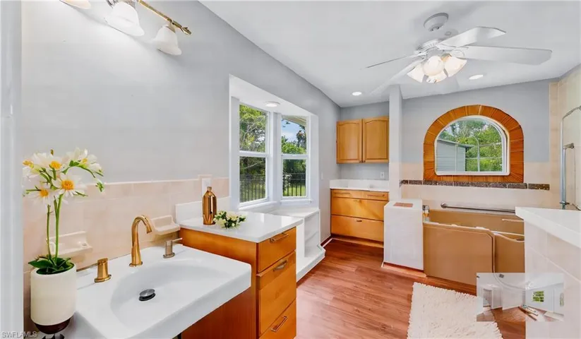 Bathroom featuring sink, plenty of natural light, wood-type flooring, and ceiling fan