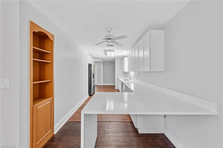 Corridor featuring dark hardwood / wood-style floors and sink