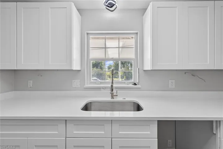 Kitchen with white cabinetry and sink