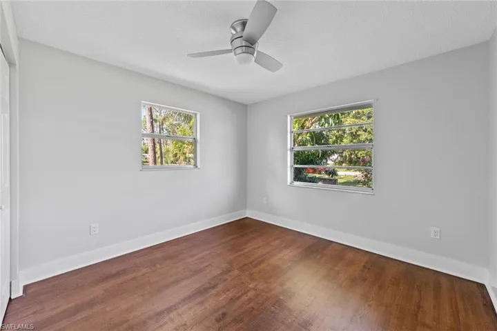 Empty room featuring hardwood / wood-style flooring, ceiling fan, and a textured ceiling