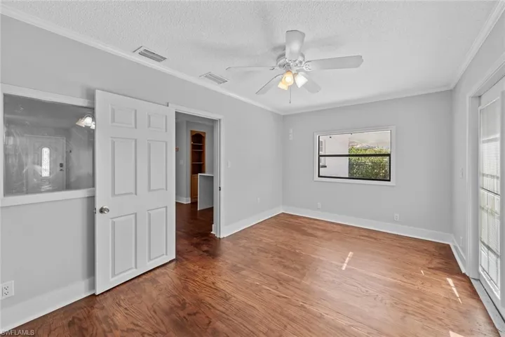 Unfurnished bedroom with ceiling fan, wood-type flooring, and a textured ceiling