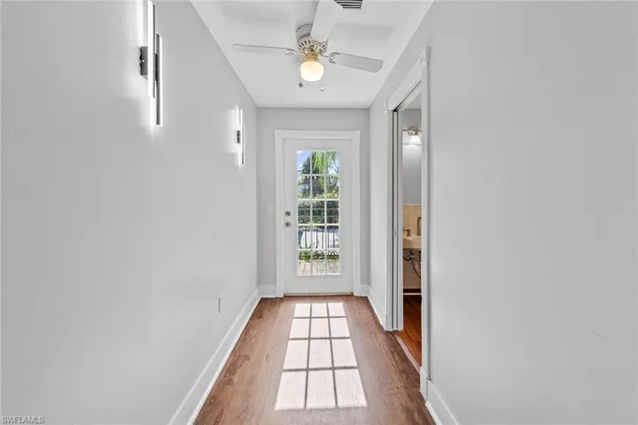 Entryway with ceiling fan and wood-type flooring