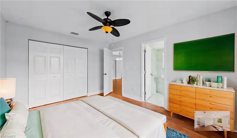 Bedroom with hardwood / wood-style flooring, ensuite bath, ceiling fan, and a closet