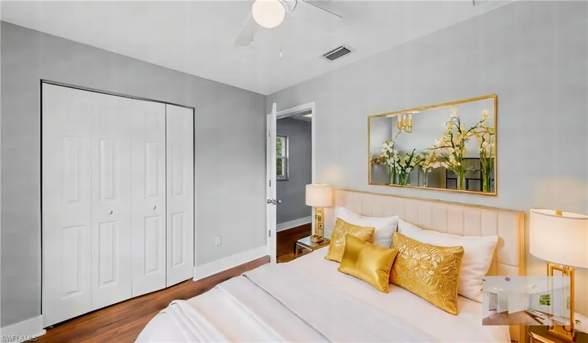 Bedroom featuring ceiling fan, dark hardwood / wood-style flooring, and a closet