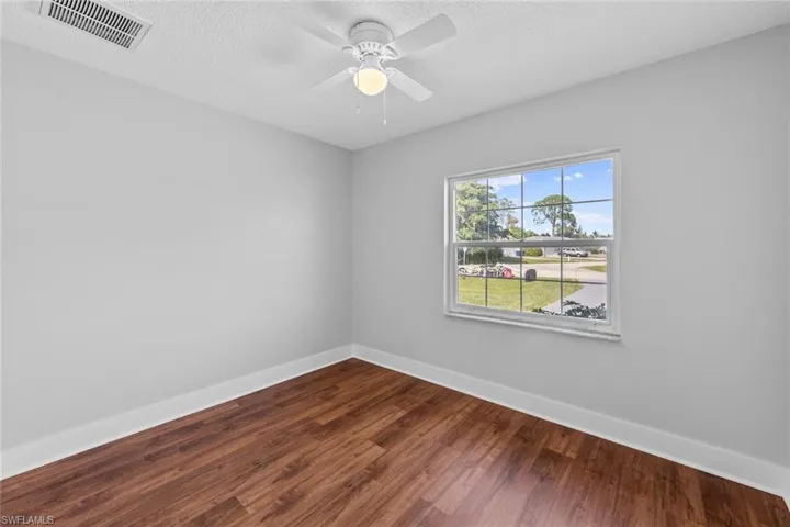 Unfurnished room featuring wood-type flooring, a textured ceiling, and ceiling fan