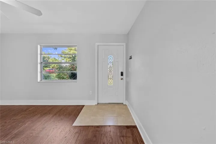 Entryway with wood-type flooring and vaulted ceiling