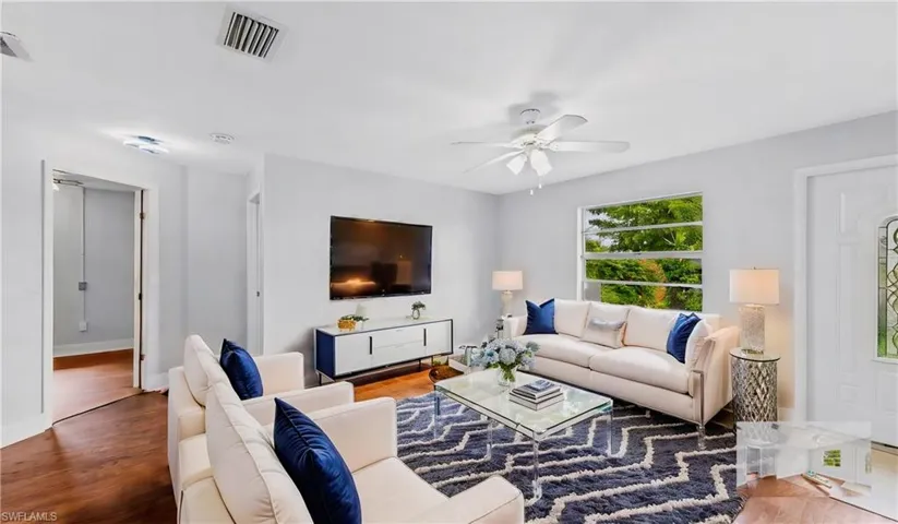 Living room with wood-type flooring and ceiling fan