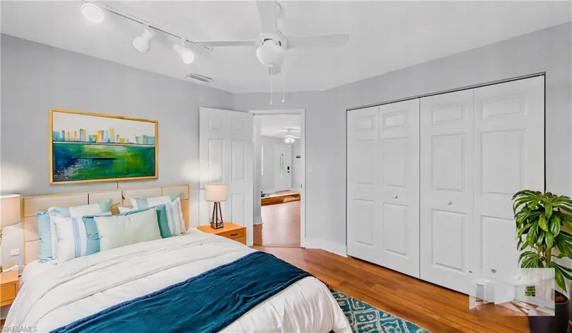 Bedroom featuring ceiling fan, light hardwood / wood-style floors, and a closet