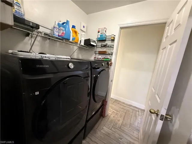 Laundry area with independent washer and dryer and baseboards