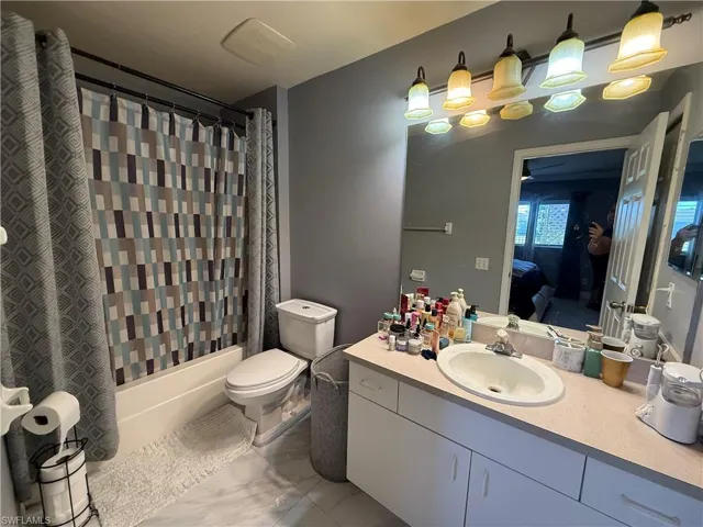 Bathroom featuring vanity, shower / bath combo with shower curtain, and ensuite bathroom