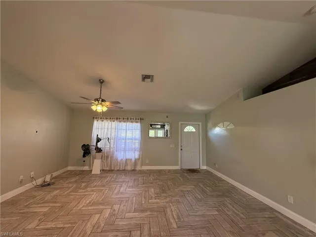 Foyer entrance with a ceiling fan and lofted ceiling