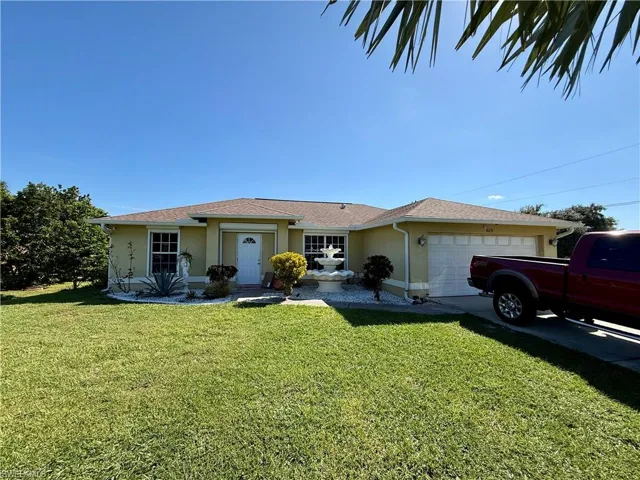Ranch-style house featuring stucco siding, a front lawn, a garage, and concrete driveway