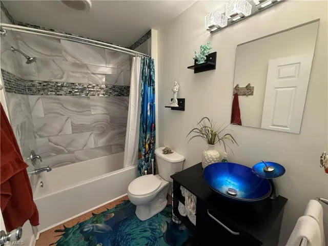 Bathroom with shower / bath combo with shower curtain and vanity
