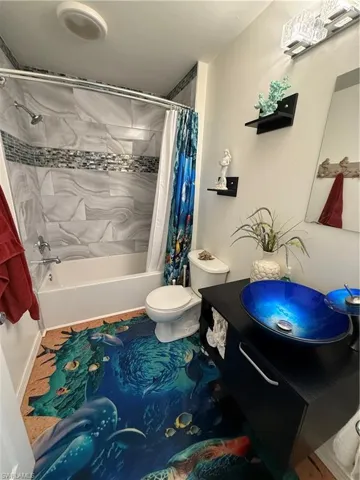 Full bathroom with vanity, shower / bathtub combination with curtain, and tile patterned floors