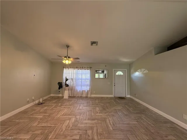Entrance foyer featuring baseboards and a ceiling fan
