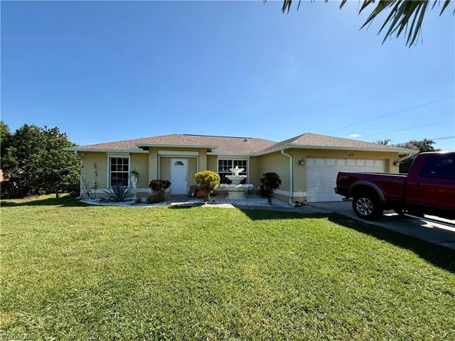 Single story home featuring stucco siding, an attached garage, a front lawn, and concrete driveway