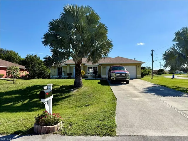 Ranch-style home with driveway, a front yard, and a garage