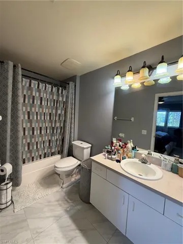 Ensuite bathroom with vanity and shower / bathtub combination with curtain