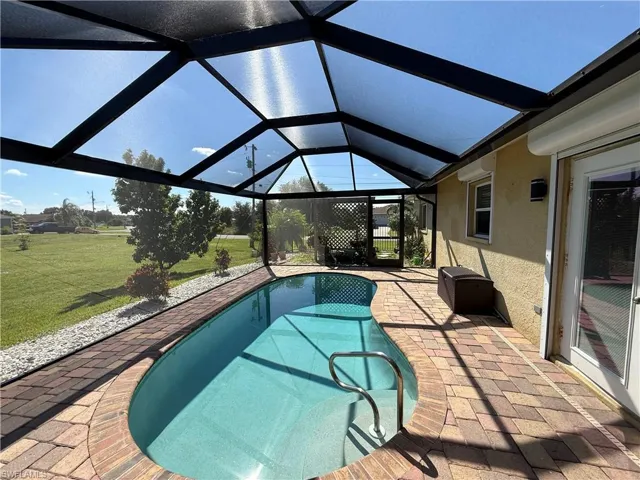 Outdoor pool with a patio, a sunroom, a lanai, and a yard
